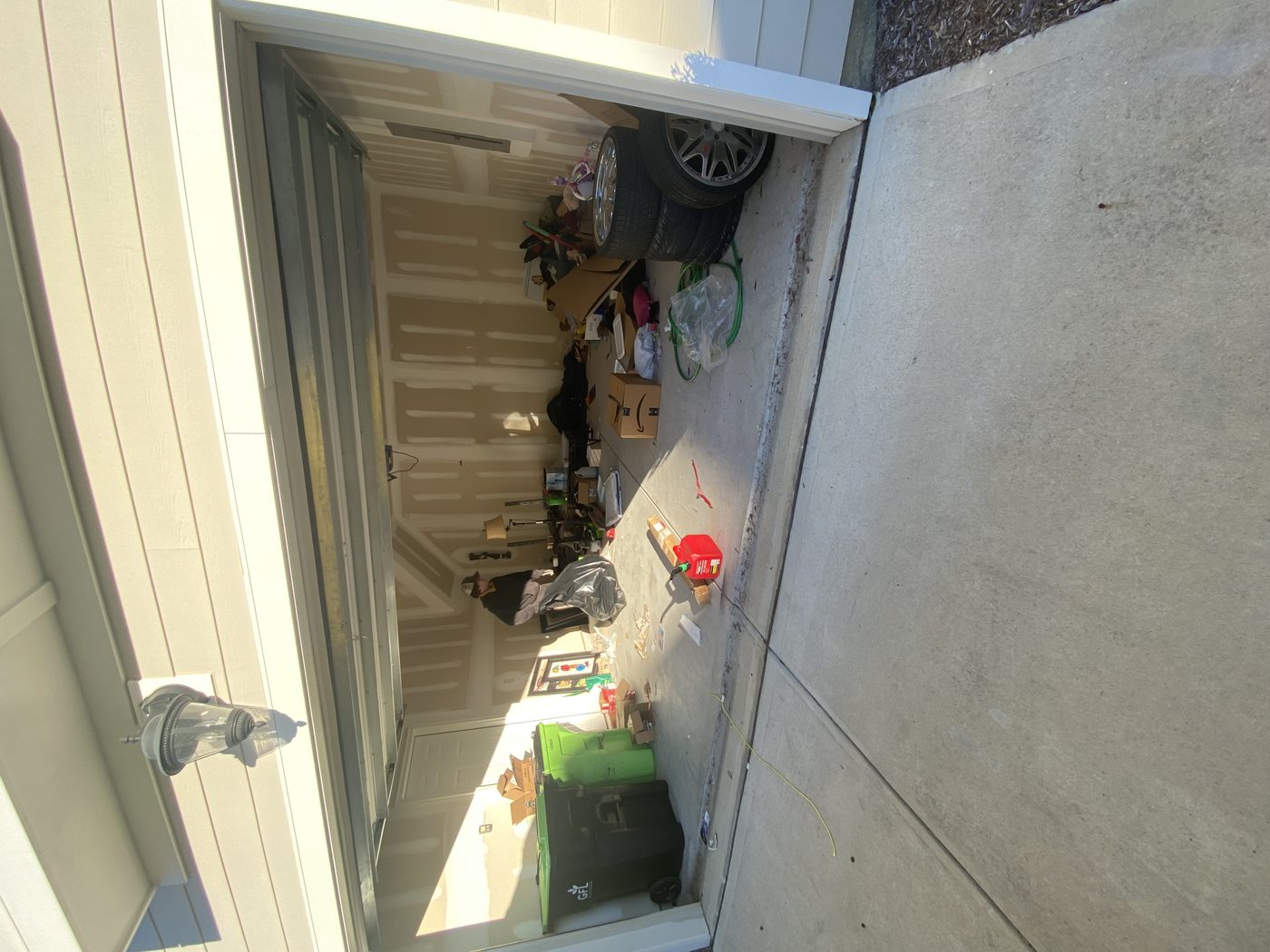 Garage packed with tires, boxes, bags, and junk — before Junk Doctors