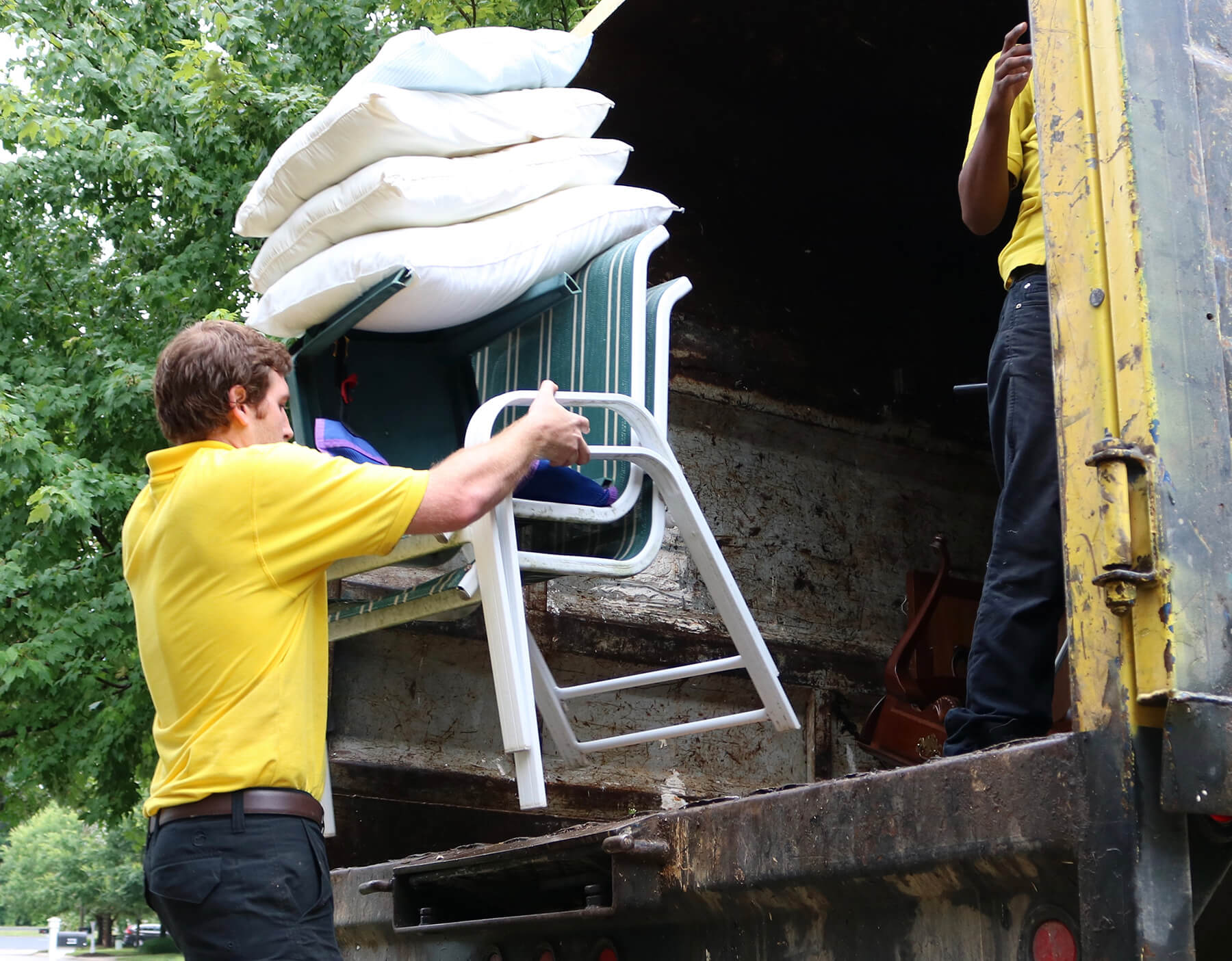 Junk Doctors team member hauling chair on truck