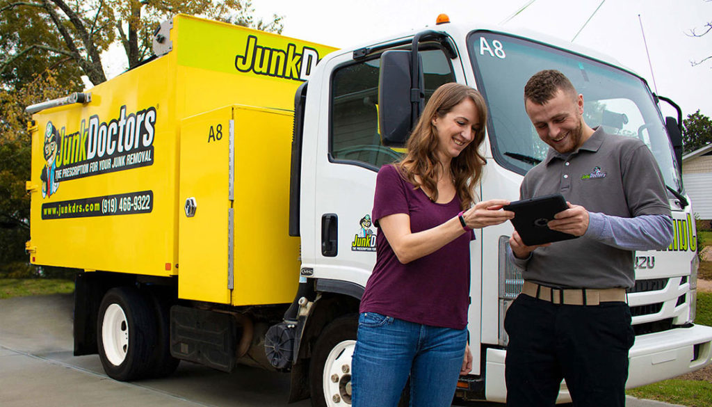 Professional sharing the cost for junk removal in Charlotte with a happy customer