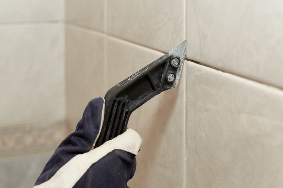Hand removing grout with a sharp tool