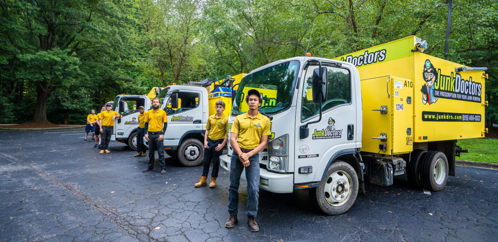 Junk Doctors crew smiling near their junk removal trucks in Youngsville